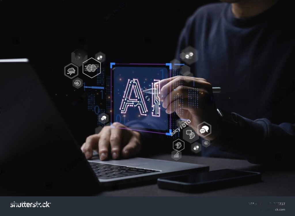A person using a laptop with a glowing hologram of "AI" and tech icons around it in a dark setting.